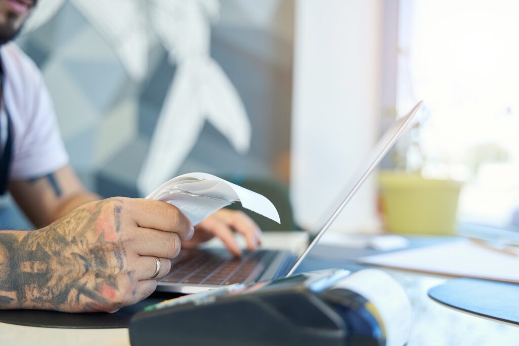 Cropped shot of person hand with stack of paper receipts